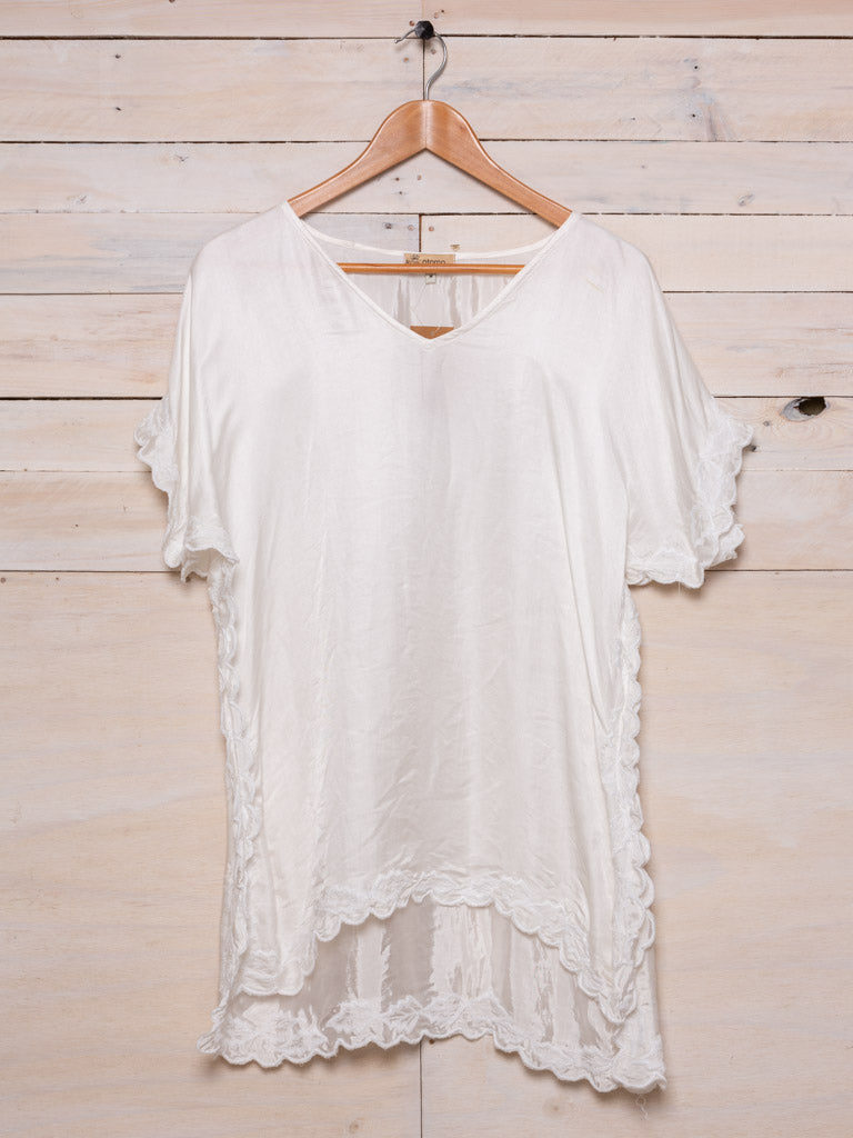 This top features a simple square cut and a generous fit. White embroidery embellishes the out line and a light natural fabric. Colour: white fabric with white embroidery