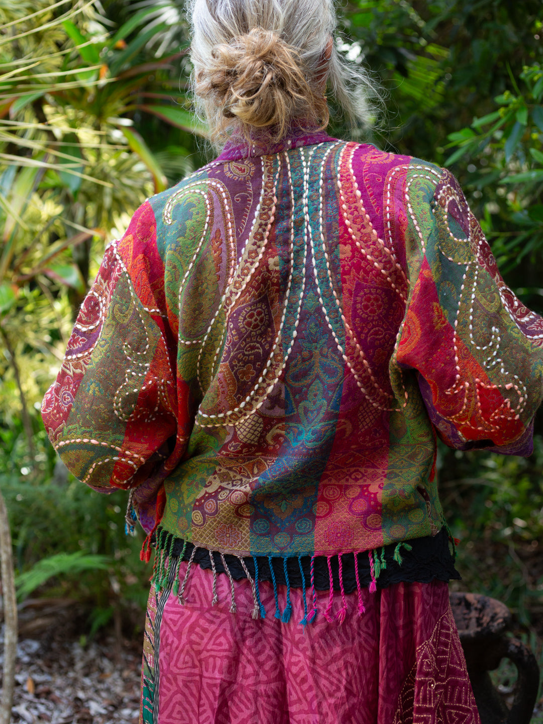 Person wearing a colorful patterned jacket in a natural setting