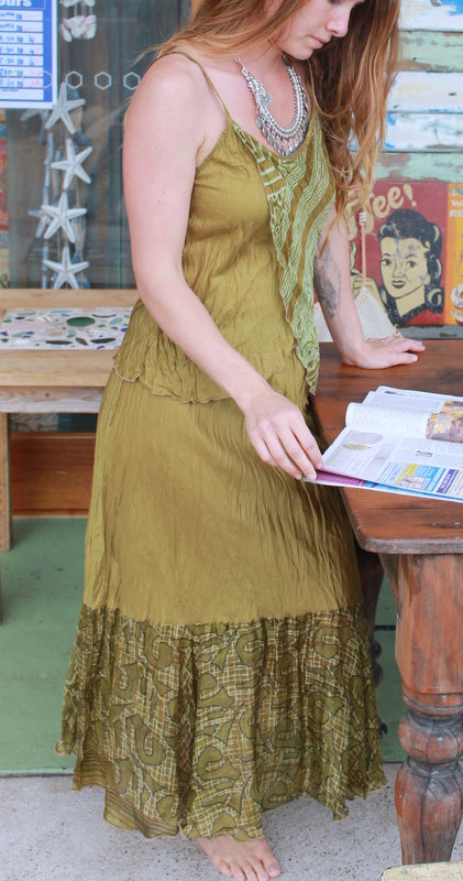 Lady wearing an olive silk and printed cami with matching skirt