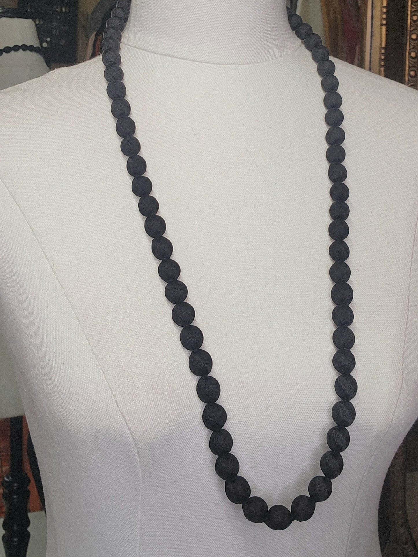 Black beaded necklace on a mannequin