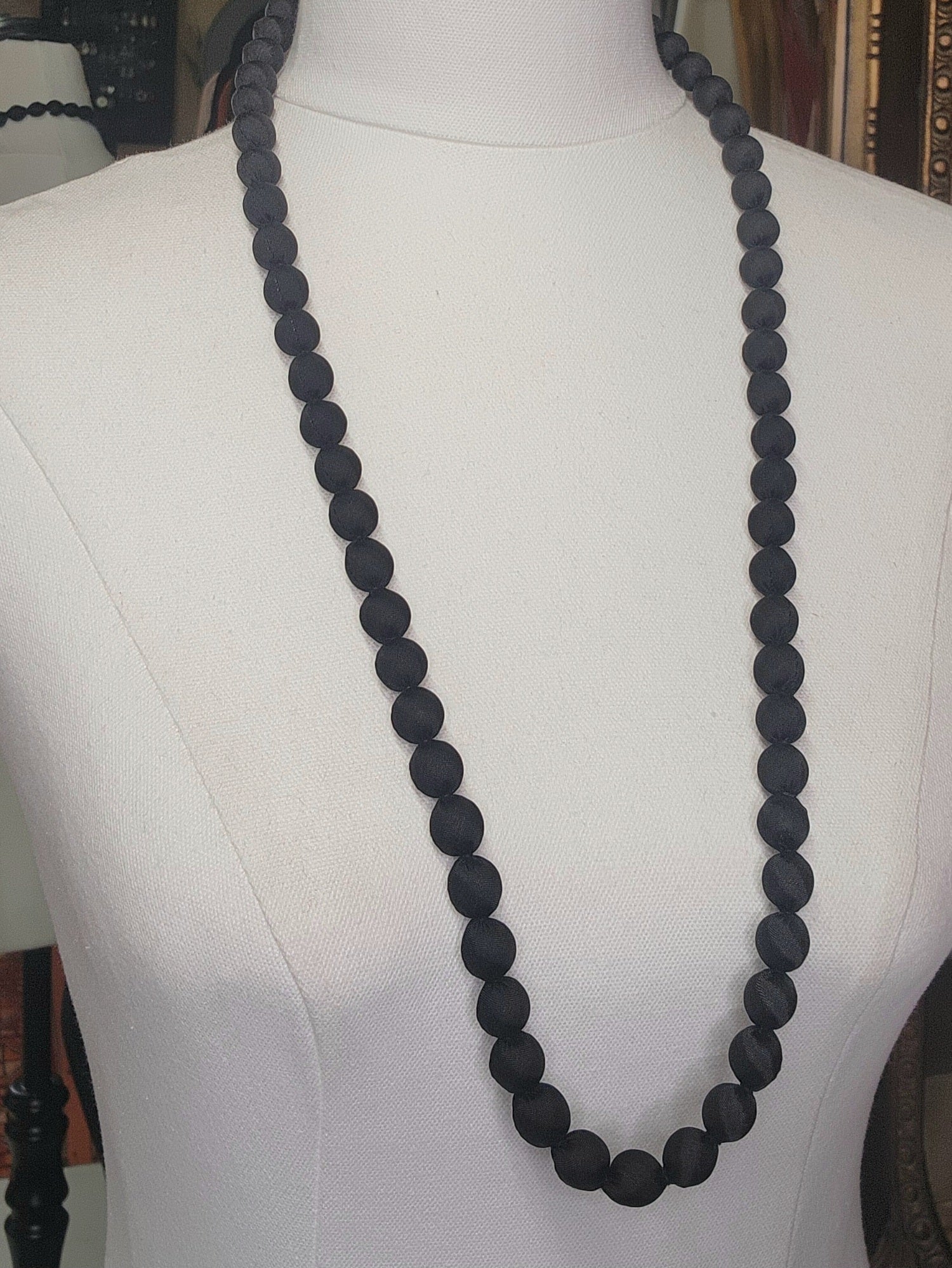 Black beaded necklace on a mannequin