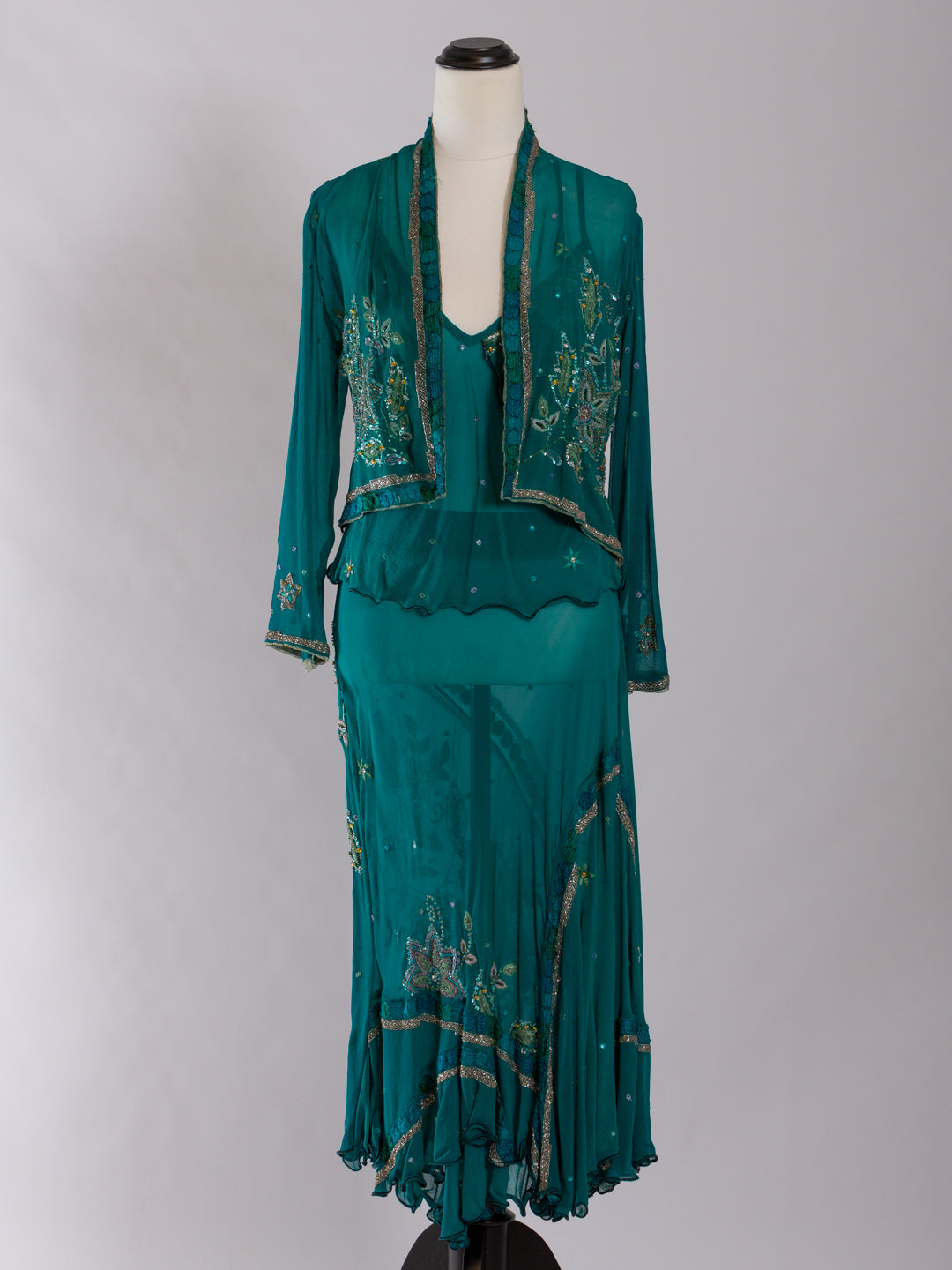 Teal three piece set with embroidery on a mannequin against a gray background