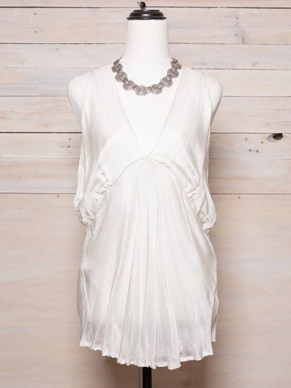 This top features a fitted bust and a low back in a light natural fabric.  Colour: White