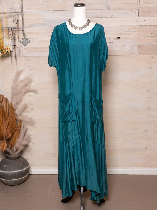 This dress features a short sleeve, a drop waist and pockets, in a light natural fabric.  Colour: Dark turquoise/ Teal