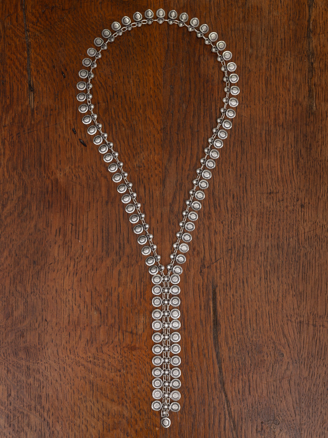 Silver necklace with beads on a wooden surface
