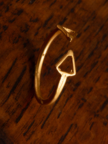 A double arrow gold ring on a timber backdrop