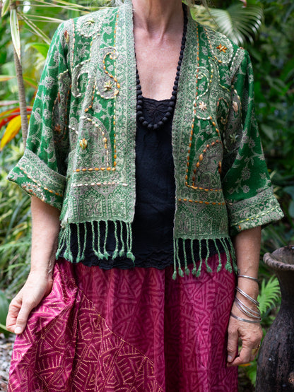 Person wearing a green patterned jacket with a blurred natural background