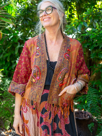 Warm toned fringed jacket on a woman in garden setting