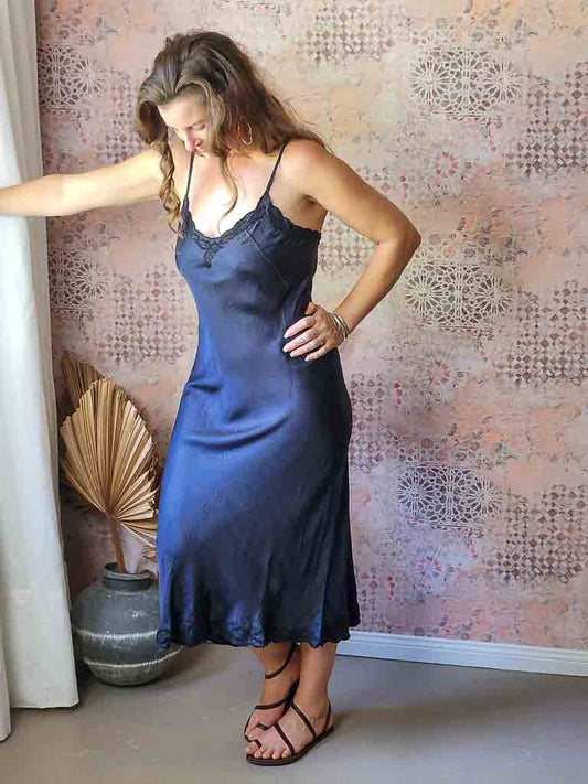 Woman wearing a satin embroidered silk slip in dark indigo