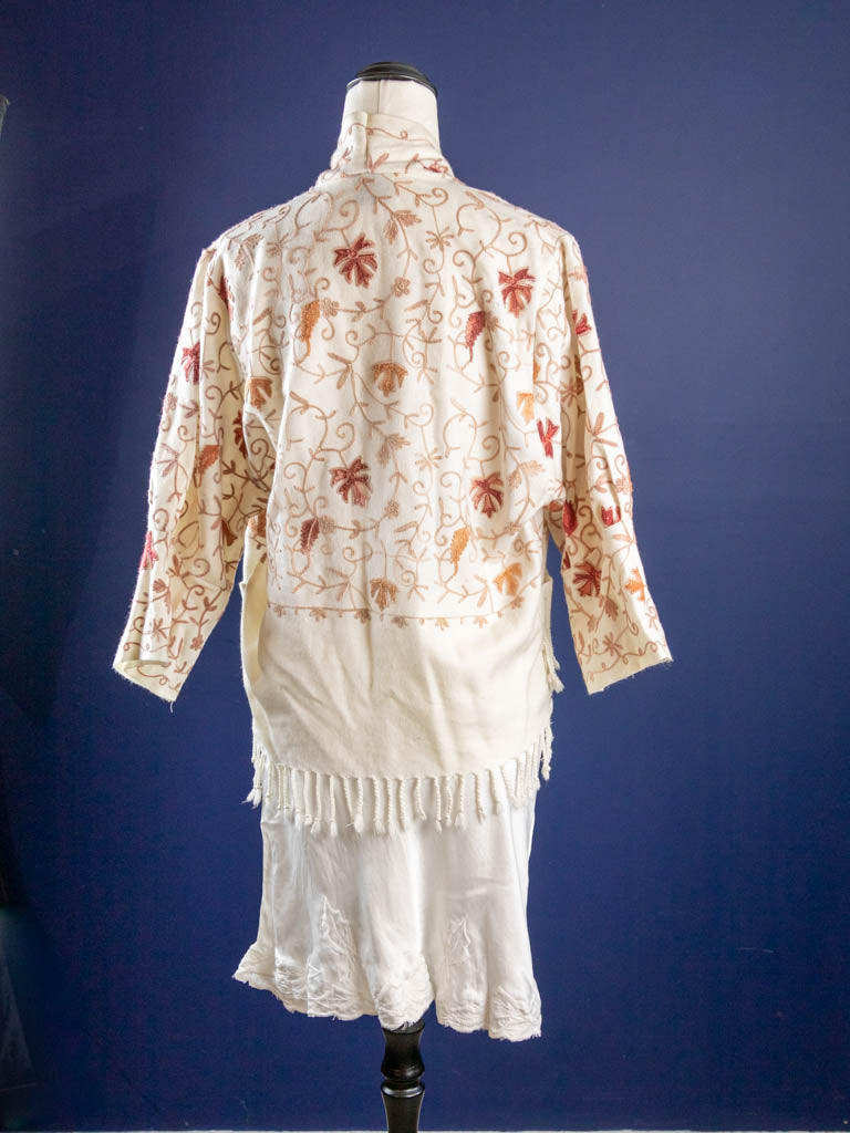 Rear view of cream jacket with fringing and vine design