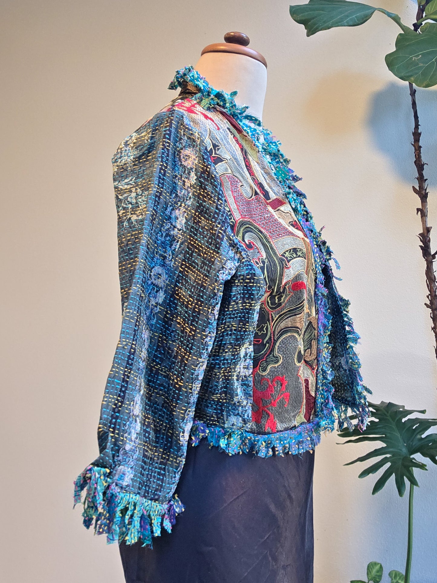 Colorful textured jacket on a mannequin with a neutral background
