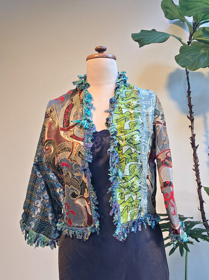 Colorful embroidered jacket on a mannequin with a plant in the background