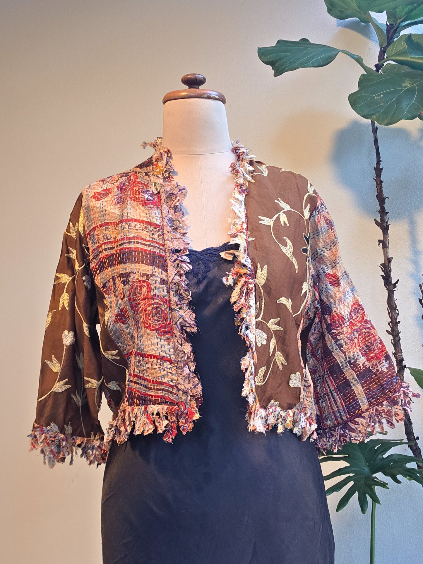 Mannequin wearing a floral patterned jacket with a plain background