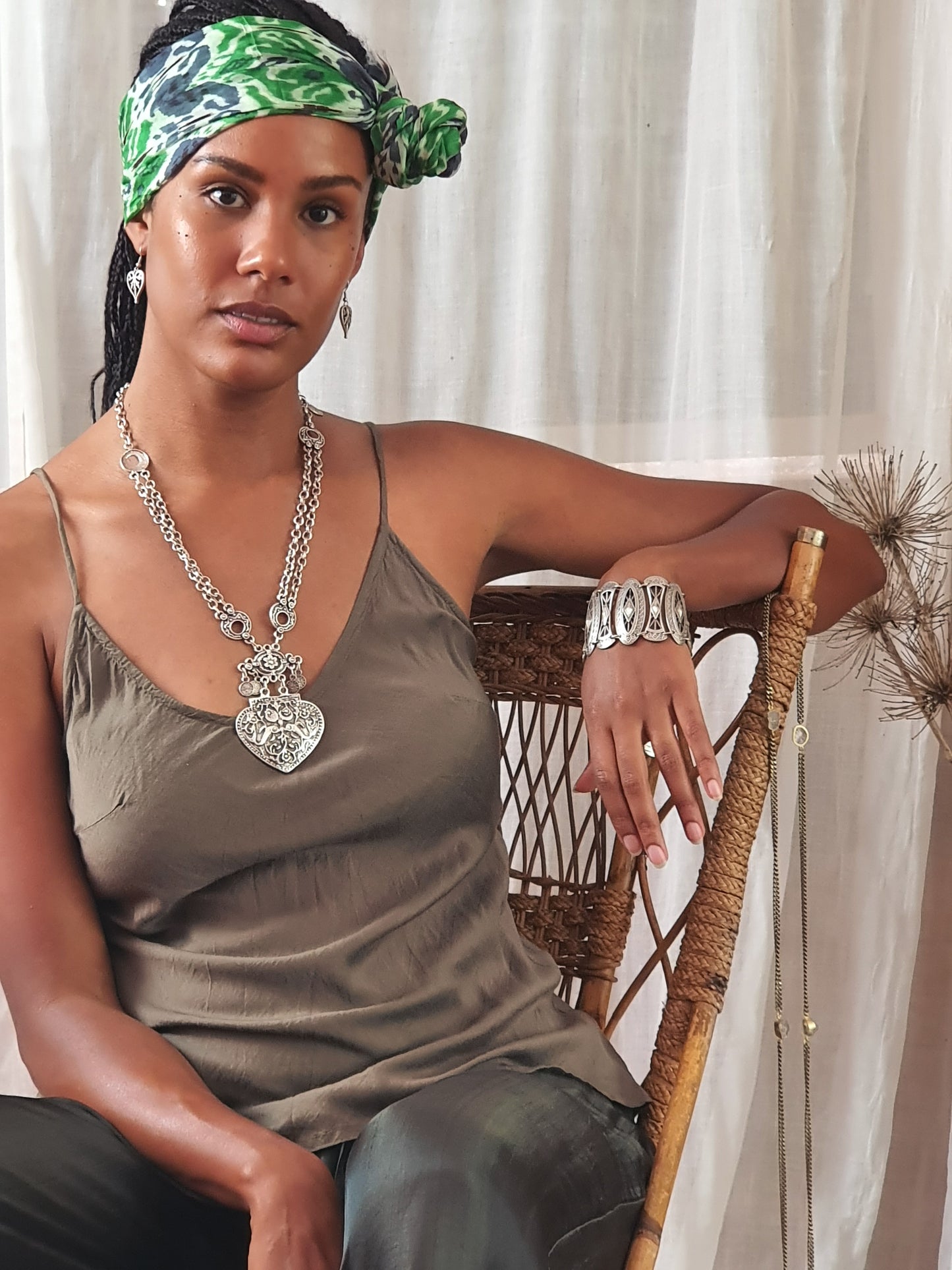 A lady leaning in a chair with silver chain bracelt