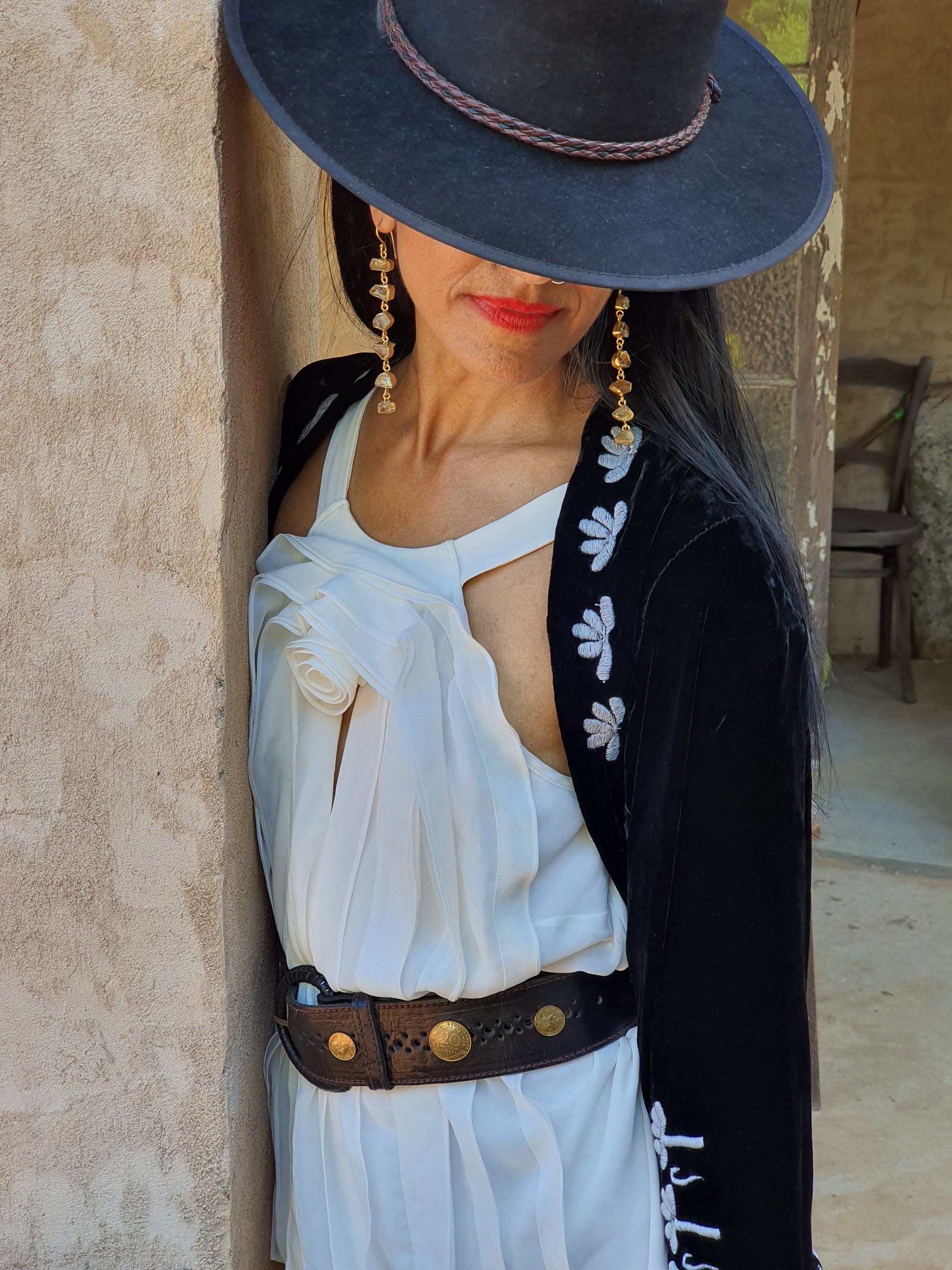 A lady in a hat with aqua marine 6 drop earrings