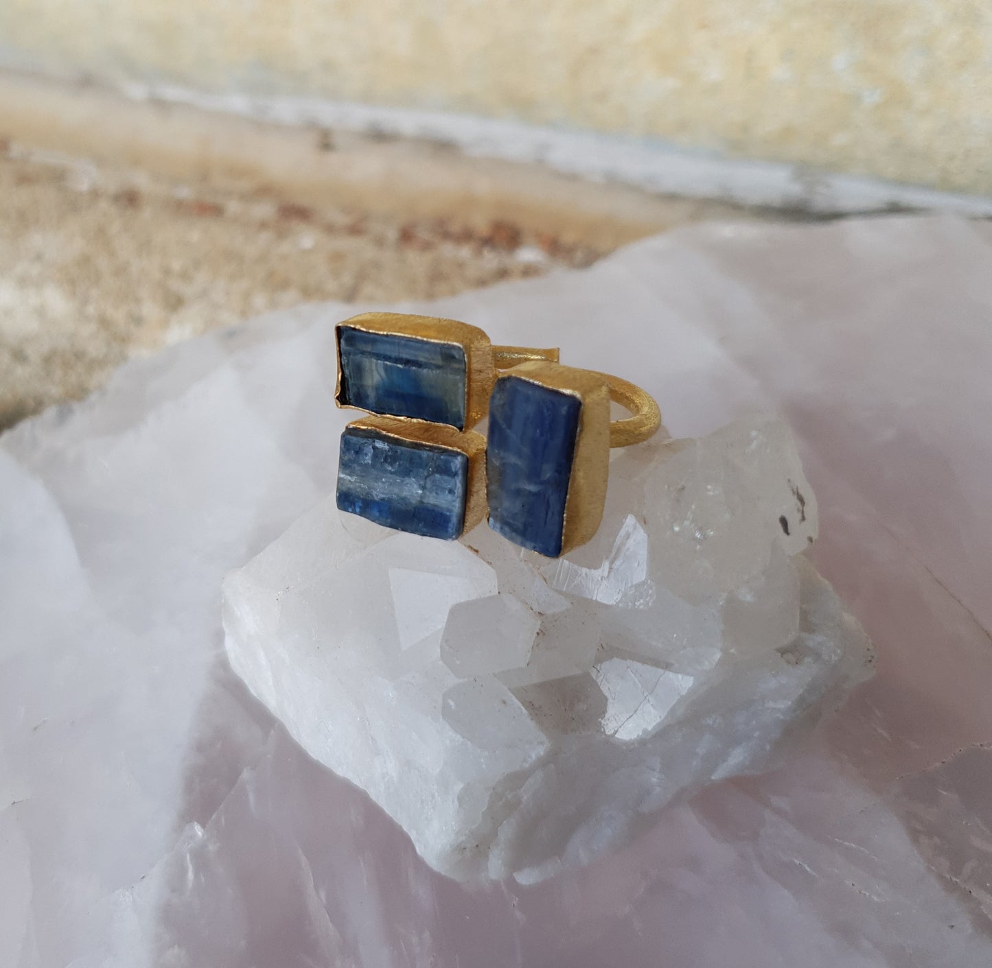 A large gold ring with a triple setting of blue kyanite