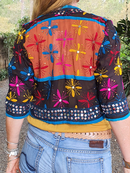Lady in a multi coloured embroidered and sequinned jacket