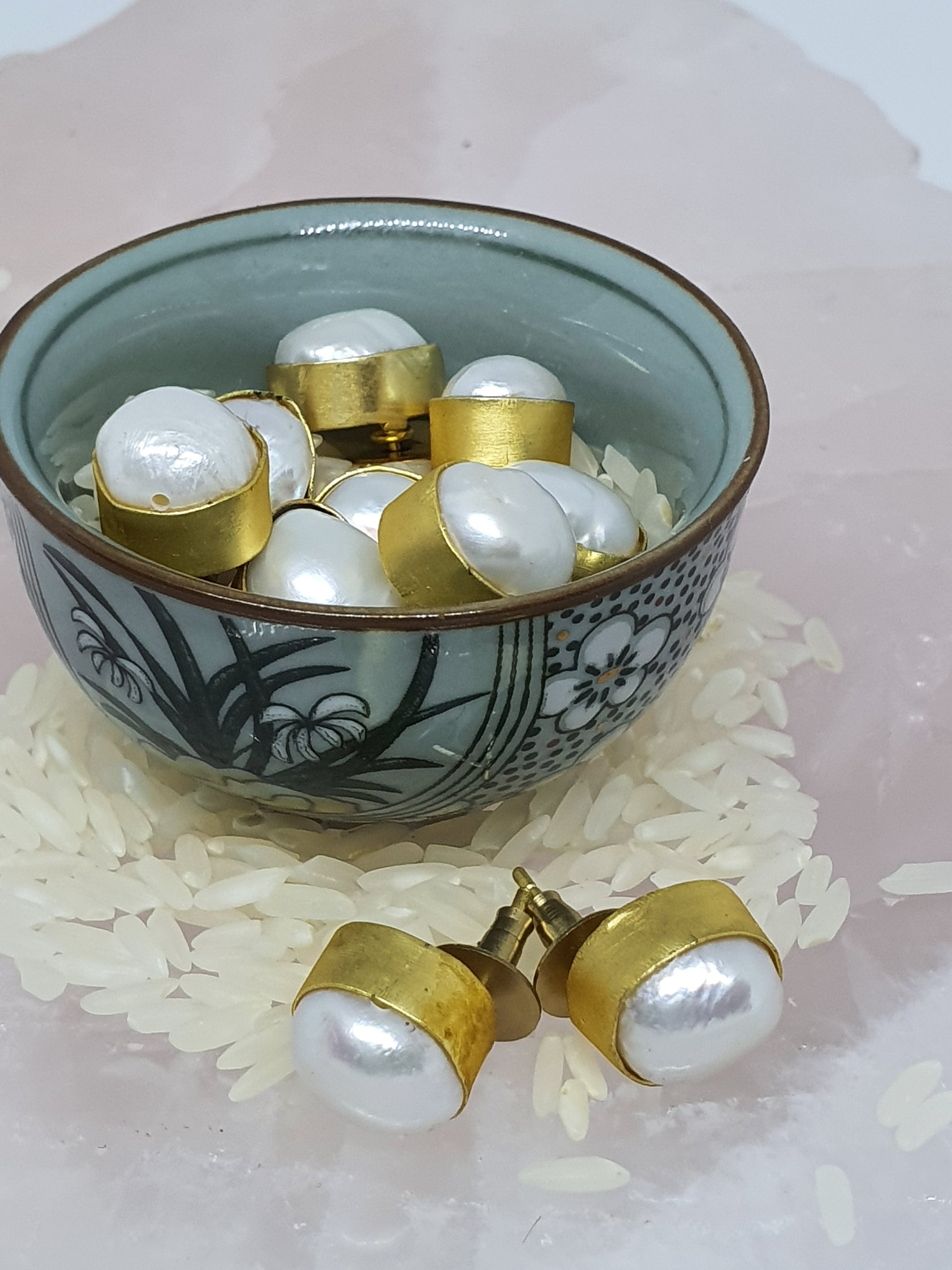 A small bowl of pearl stud earrings