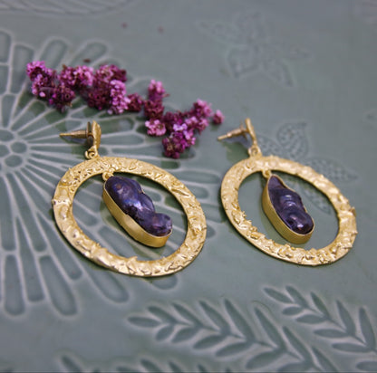 Black pearls in large gold hoop earrings