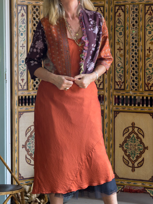 Lady wearing a rust slip and choc-rust satin jacket