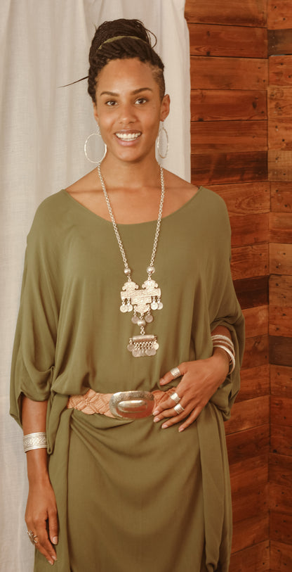 Lady wearing olive kaftan with lots of silver jewellery and a wide cuff