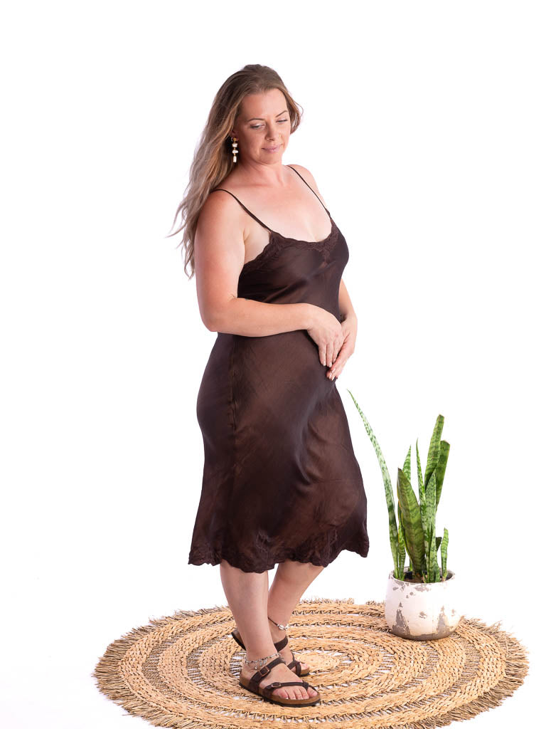 A woman wearing deep chocolate bronze silk satin slip