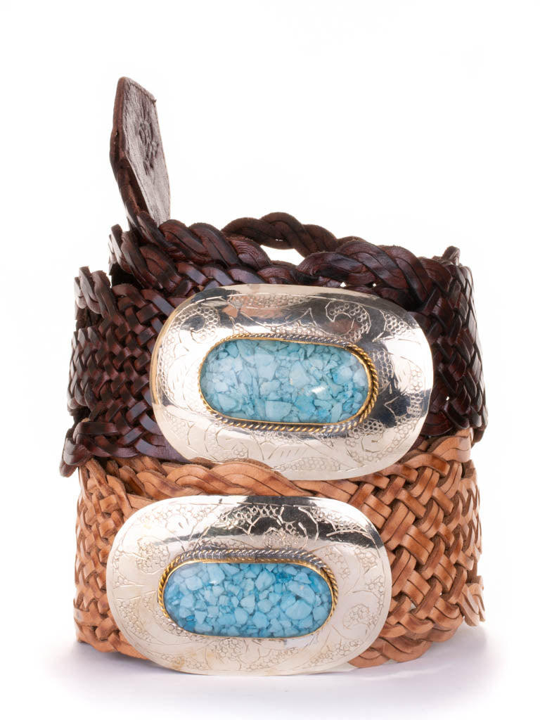 wide woven chocolate and tan coloured leather belts with an oval buckle stacked.