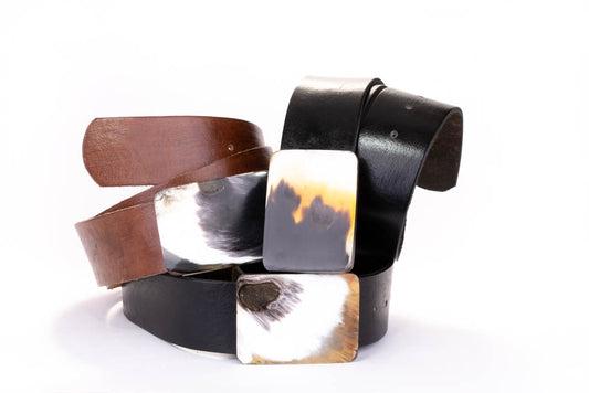  A group of Rectangular bone buckle on a black leather belt.