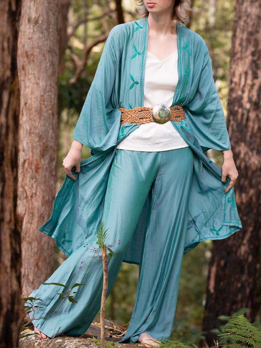 Model wearing long turquoise silk pants 