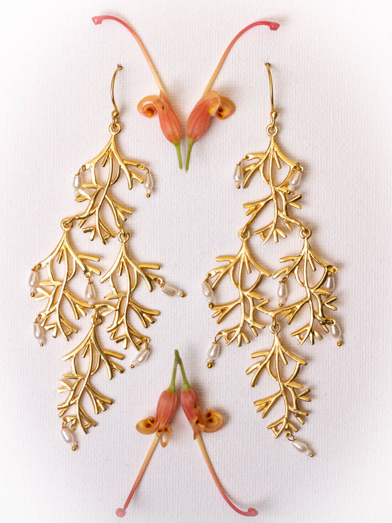 Pearl and gold earring in the shape of a willow branch by Taboo Fashion Accessories.