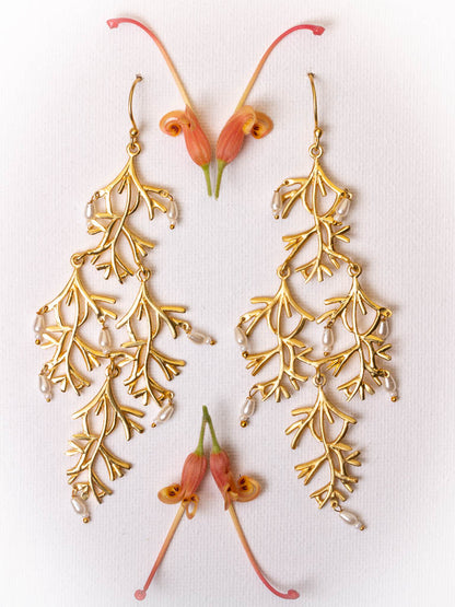 Pearl and gold earring in the shape of a willow branch by Taboo Fashion Accessories.