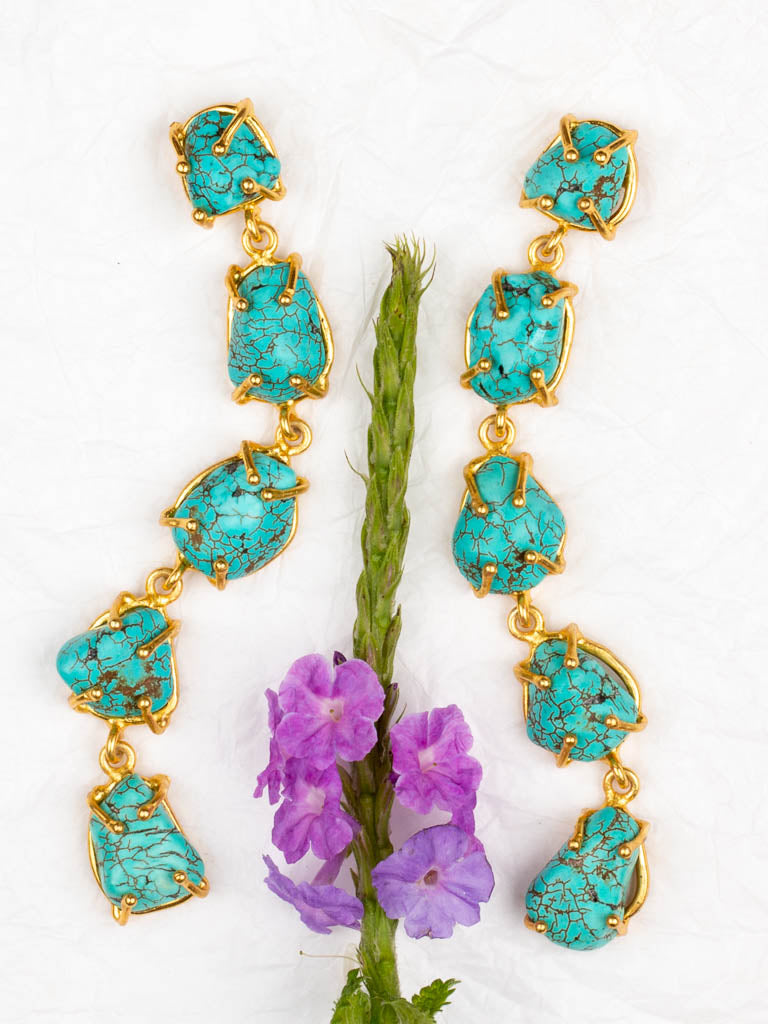 Claw set turquoise and gold earrings with floral display