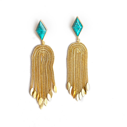 Diamond shaped turquoise set in gold border with stud back. Multiple dangling gold tales