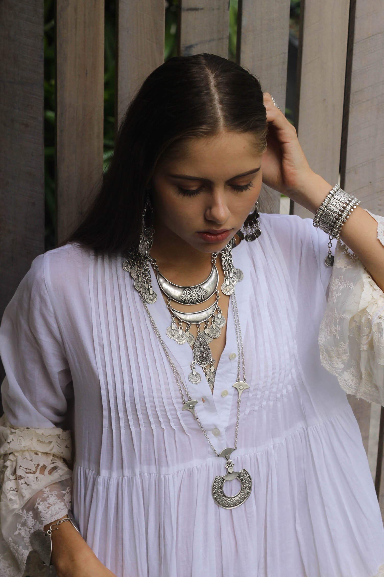 Woman wearing layers of silver boho necklaces