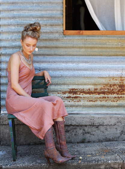 Woman wearing a long silk slip in peach colour