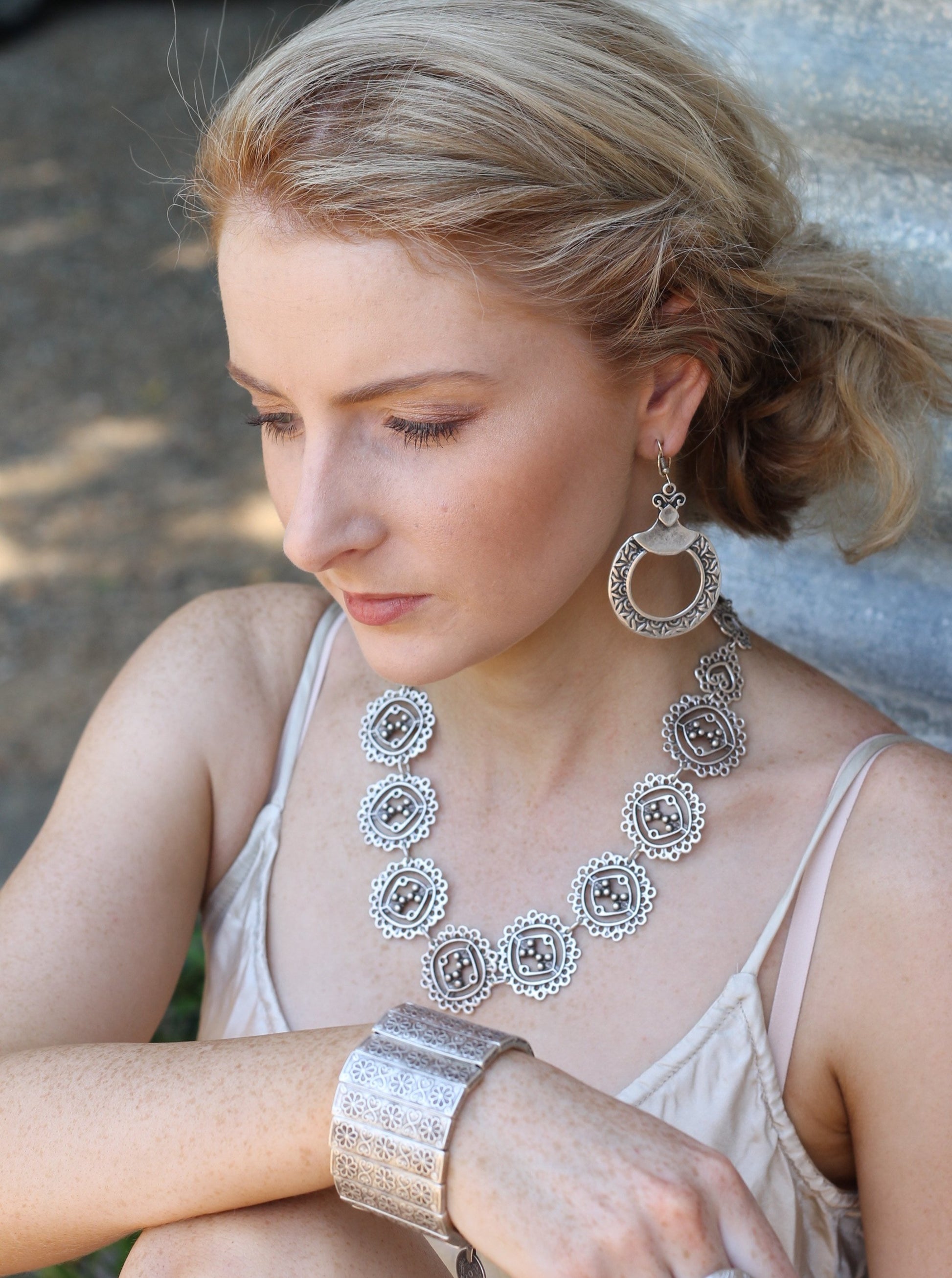 Woman wearing a lace like necklace and other silver jewellery