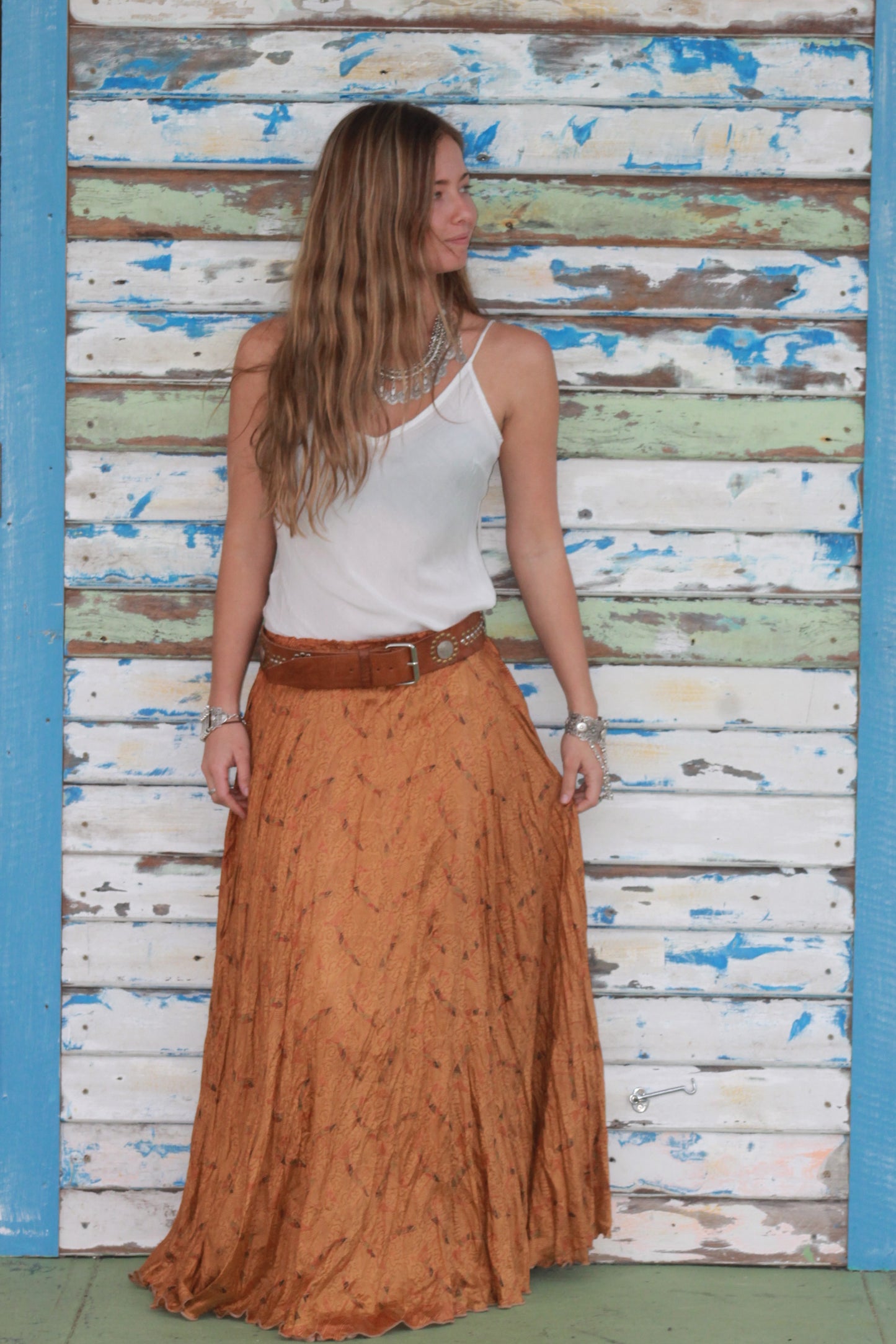 Lady in a whitel silk cami and rust silk skirt 