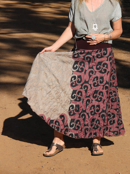 Woman holding out skirt to show tribal pattern