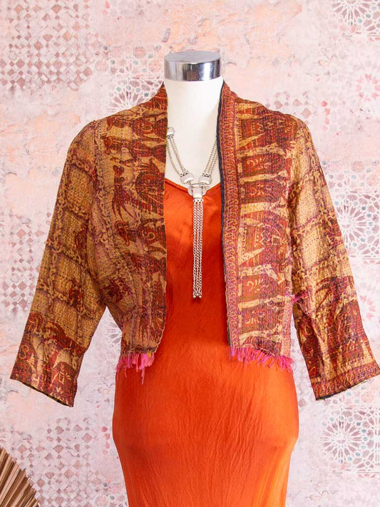 Reversible cropped jacket, with Muted Red with square patterns and jungle folk on one side the other, Lime background with bold black jungle patterns.