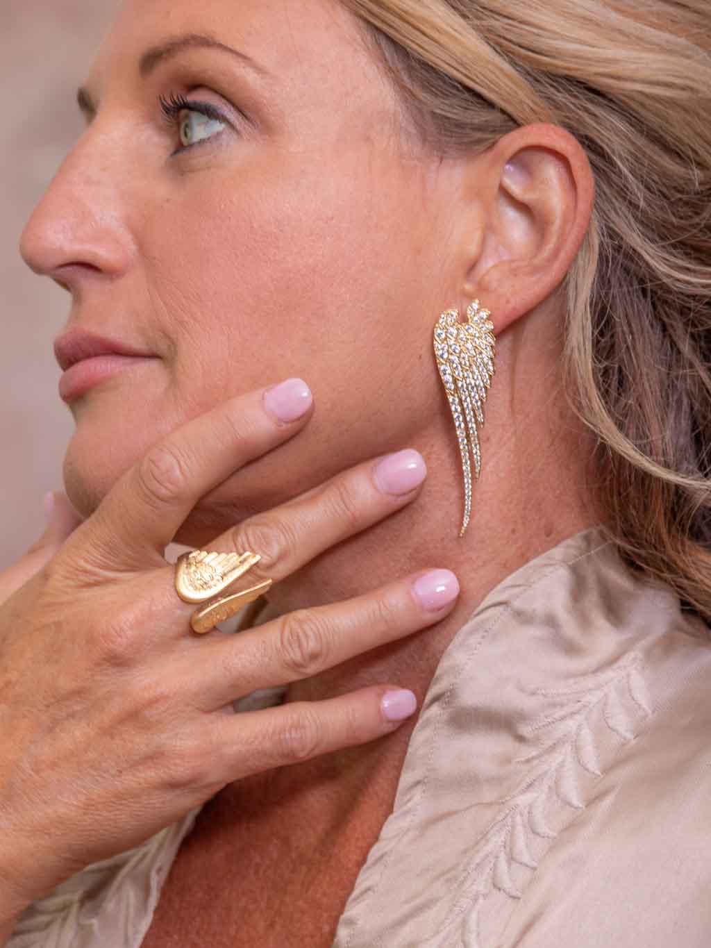 Woman wearing clear angel wing crystal earrings
