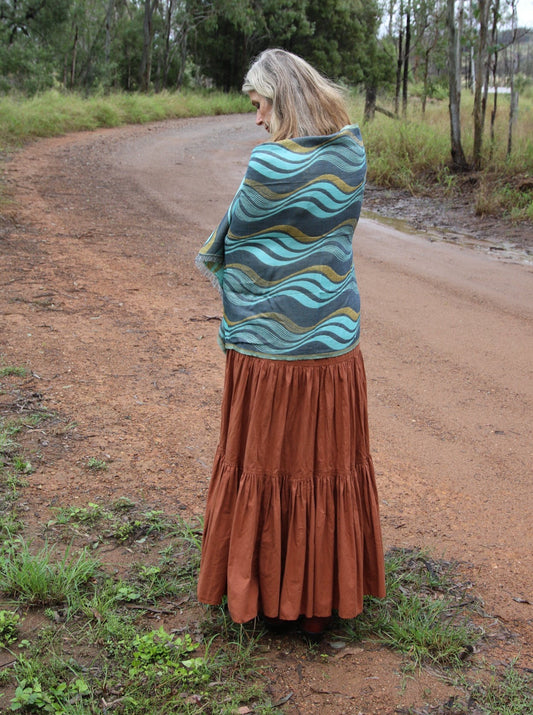 Woman wearing a turquoise scarf with swirl pattern