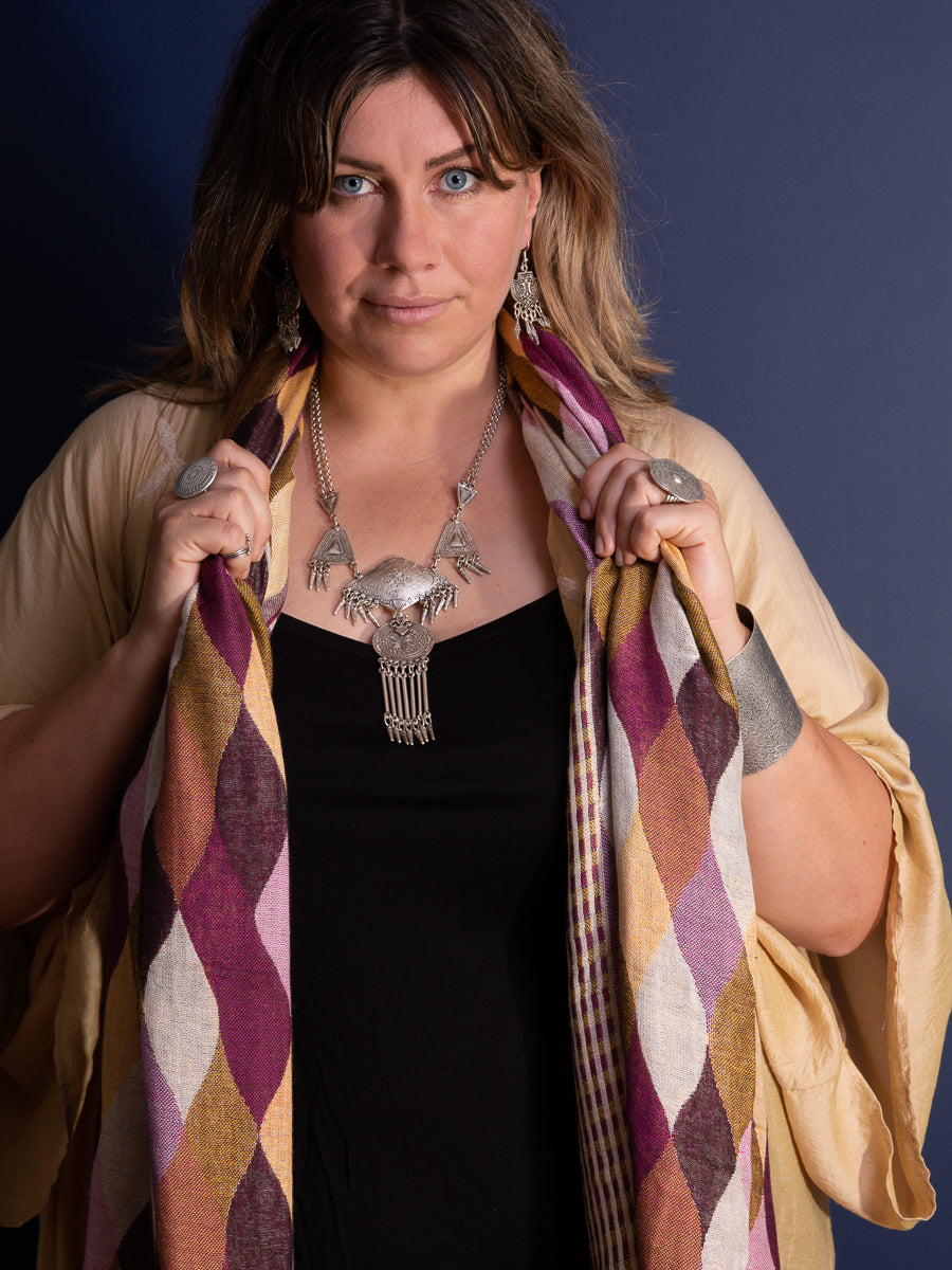 Woman wearing silver necklace and checkerboard scarf