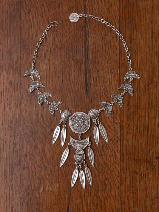A detailed necklace including feathers, medallions and shields. Hook closure
