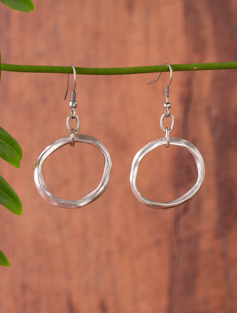 Beaten hoops dangling from hooks.