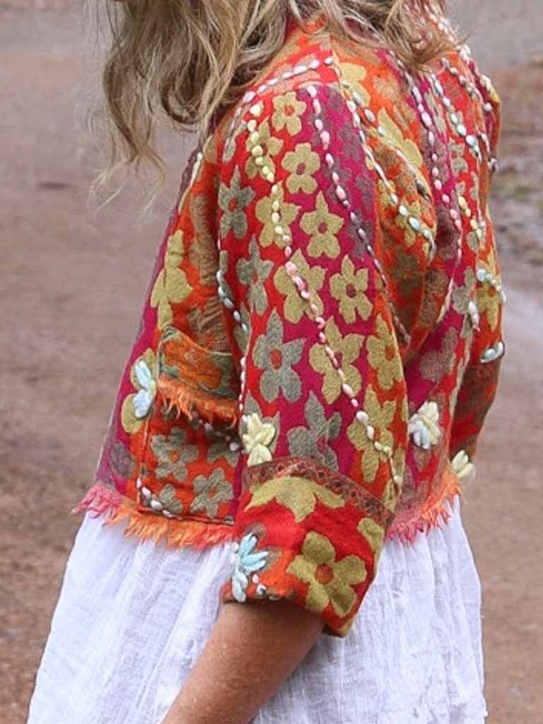 Side view of Fringed wool jacket in orange with daisies