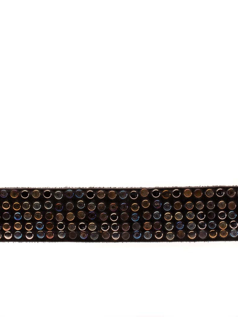 close up of leather belt covered in multi hued metal rivets 