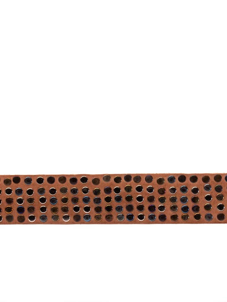 close up of leather belt covered in multi hued metal rivets 