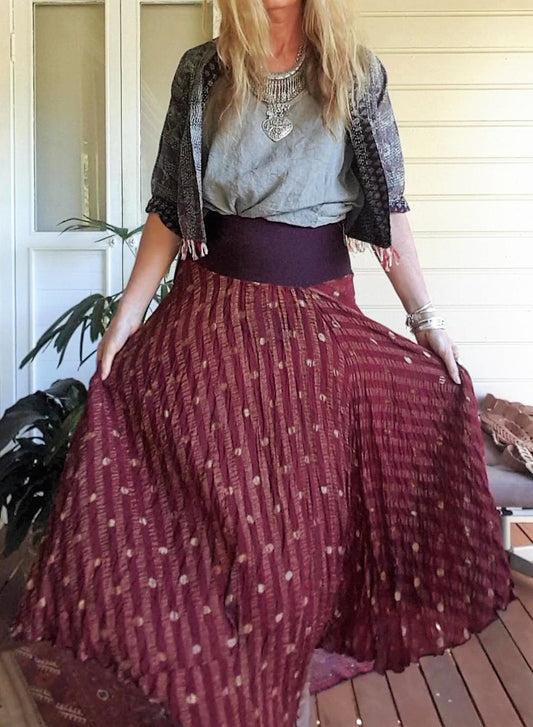 Lady wearing a wine coloured skirt with metal thread stitching