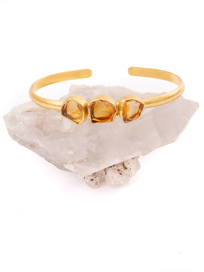 Citrine raw cut gold bangle sitting on a crystal