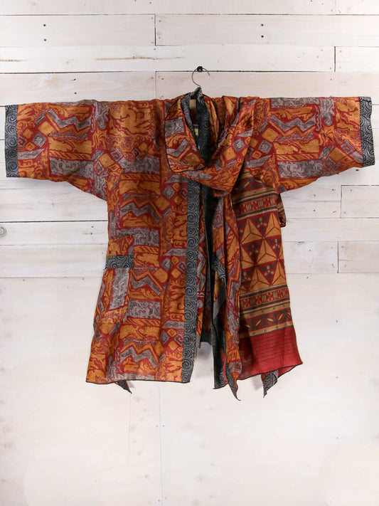 wool kimono styled jacket with block pattern on burnt orange background.